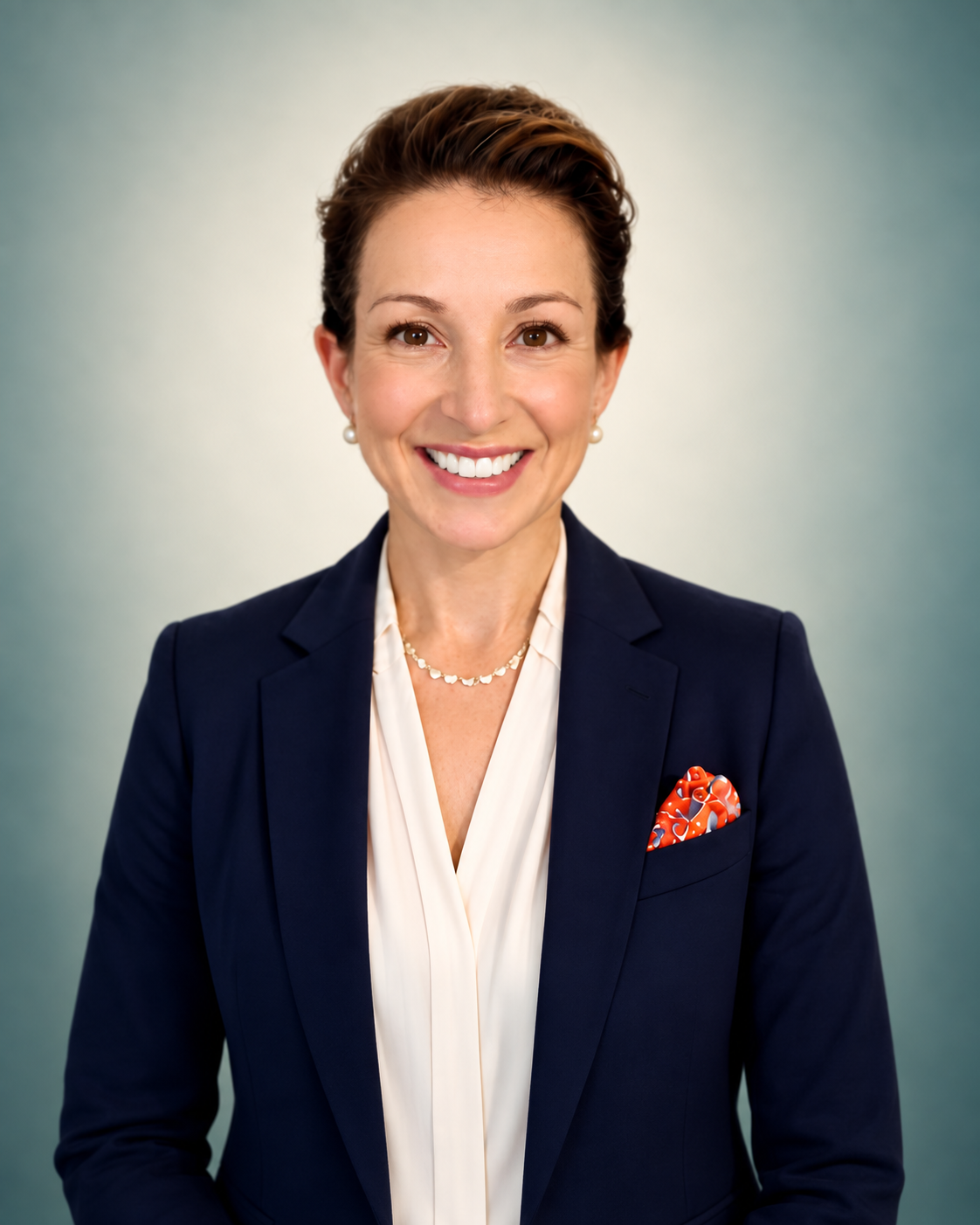 Elizabeth Carpenter, smiling in a navy blazer against a soft cream and teal background